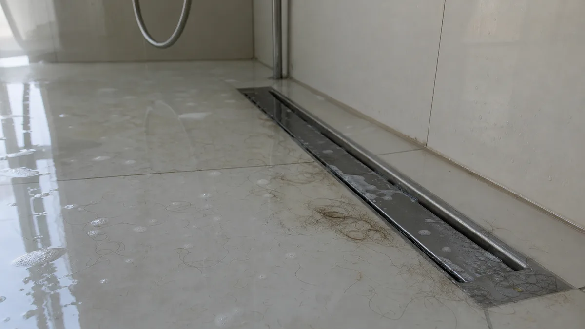 Bodengleiche Dusche mit Schlitzablauf und stehendem Wasser – Abfluss verstopft