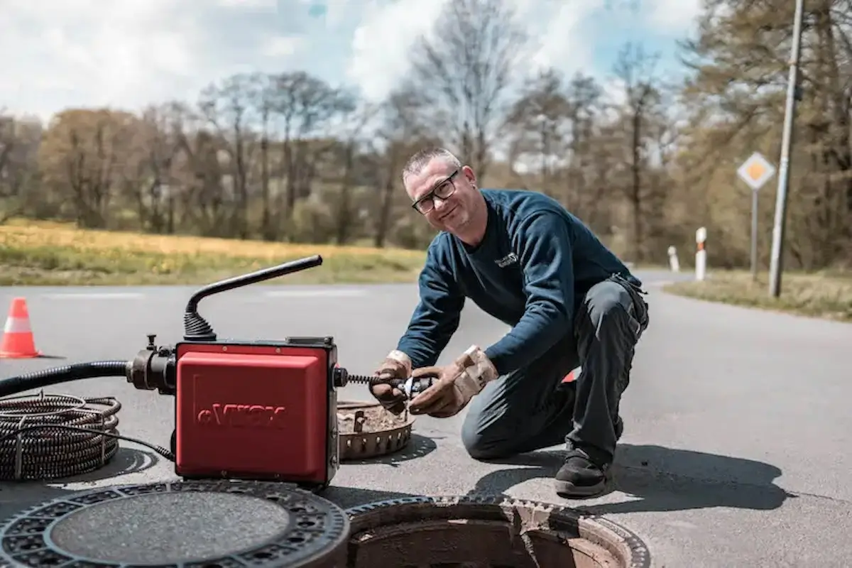 Besorgter Hausbesitzer spricht mit Techniker über Wasserschaden durch verstopftes Rohr