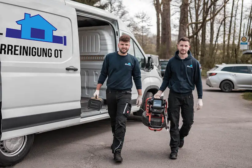 Fachkräfte für Kanalreinigung Antrifttal beim Einsatz mit Werkzeug und Firmenfahrzeug.