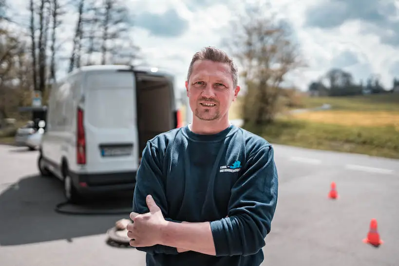 Fachmann für Kanalreinigung Bad Laasphe vor einem Einsatzwagen.