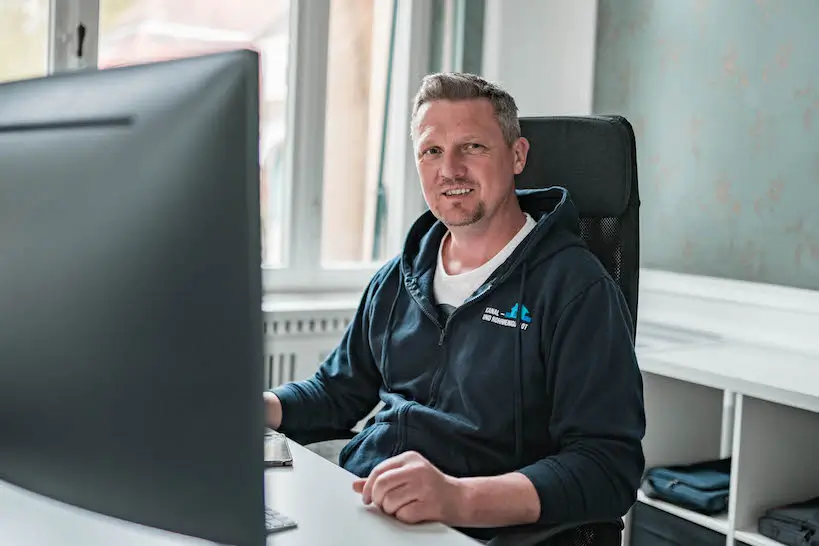 Fachmann für Kanalreinigung in Siegen am Arbeitsplatz mit Computer.